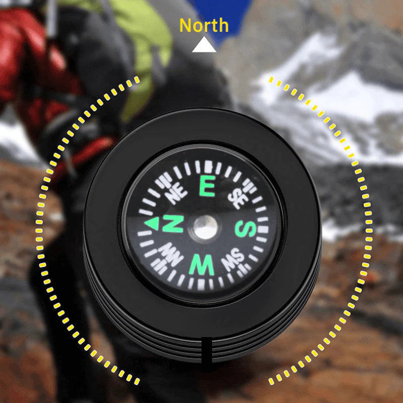 Close-up of a built-in compass on the end of a black flashlight, with North marked above