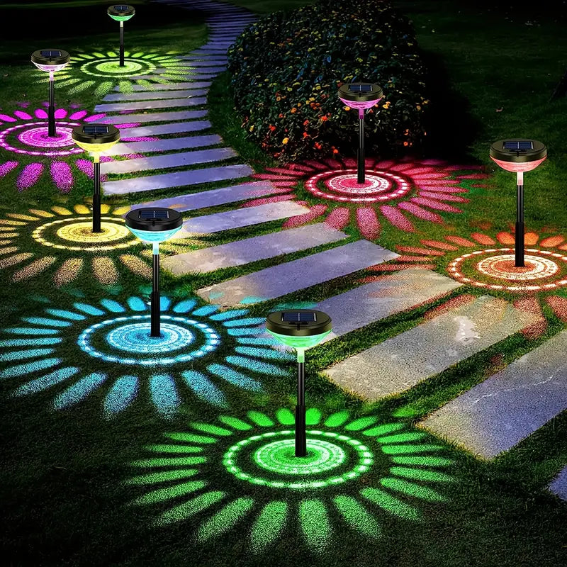 Solar garden lights with color mandala patterns projected on a stone pathway at night