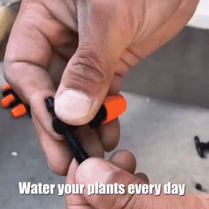 Hand fitting an orange and black irrigation tube connector outdoors