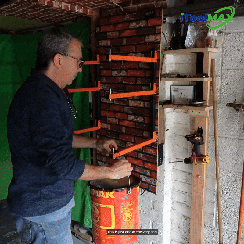 Man attaching orange wall rack arms to a brick wall in a workshop