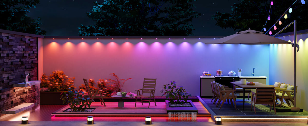 Backyard patio at night with color-changing wall lights, a dining set and deck lighting
