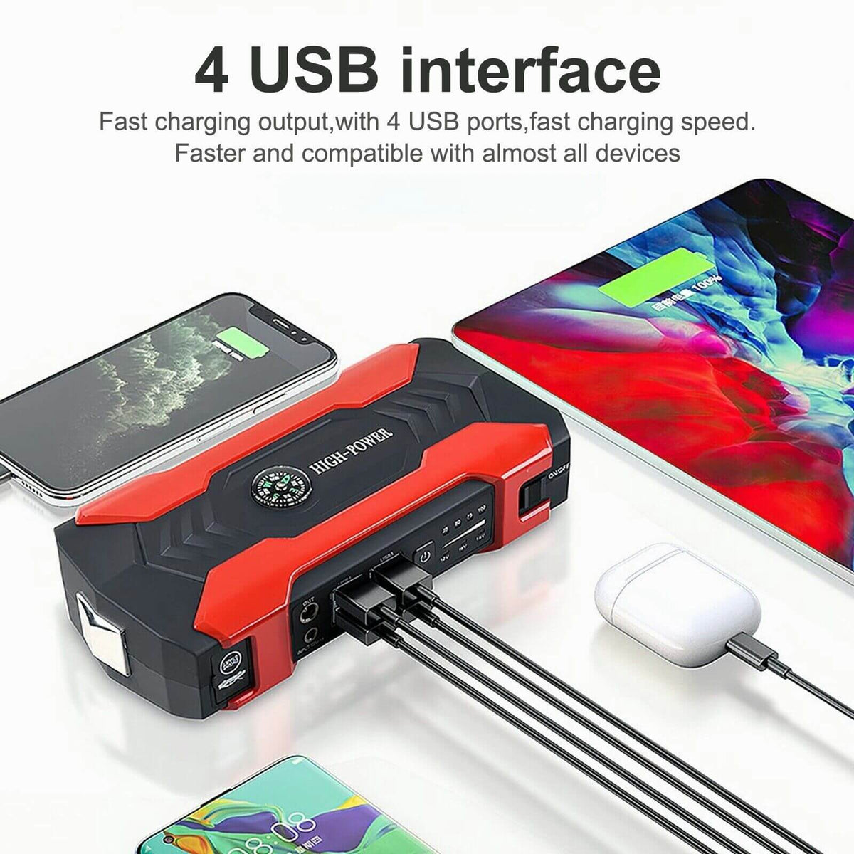 Red jump starter with four USB ports charging a phone, tablet and earbuds